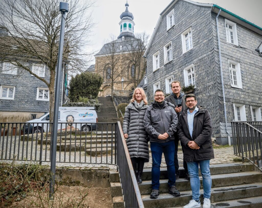 Links oben im Bild auf dem "Laternenpfahl:neue Wlan-Hotspot durch einen kleinen Sender (links im Bild) an der Klostertreppe. Das neue Angebot stellten (v. l.) Bezirksbürgermeisterin Ruth Fischer-Bieniek, Andreas Freund (Stadt Solingen), Lars Rennert und Tobias Ziemann (beide Technische Betriebe Solingen) vor.